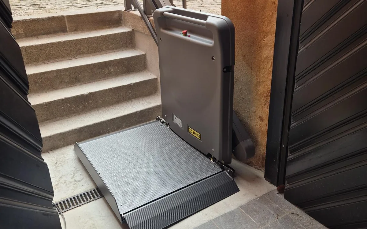 Goederen-traplift BCSP platform 225 kg compleet onderaan stenen trap met deployed ramp en handle