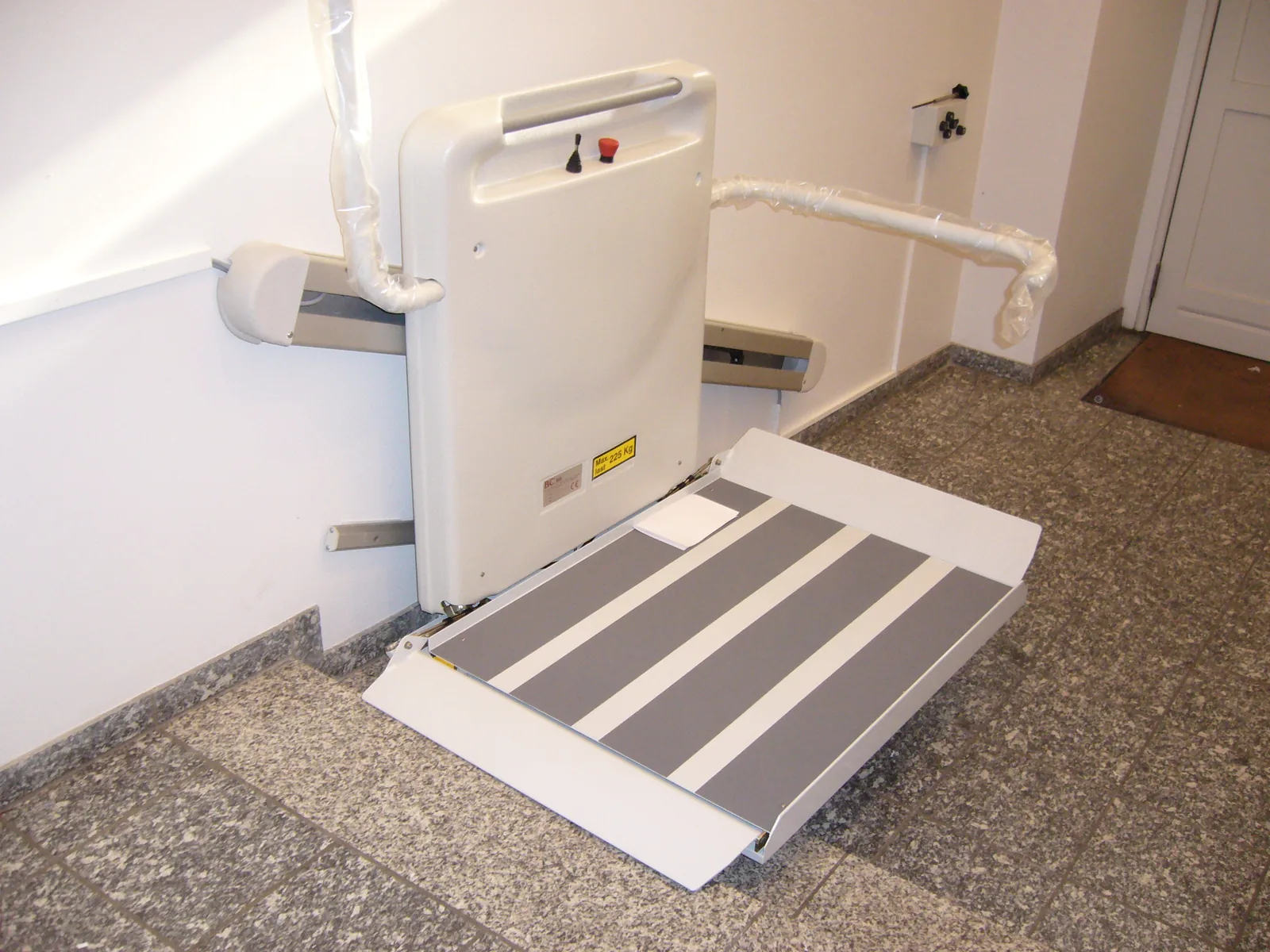 Plateaulift rechte trap binneninstallatie — platform en oprijdramp uitgeklapt op hardstenen vloer